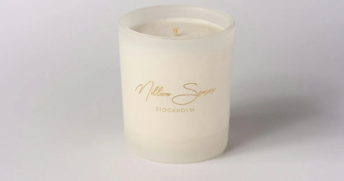 White candle in a frosted glass vessel – example of a premium candle container
