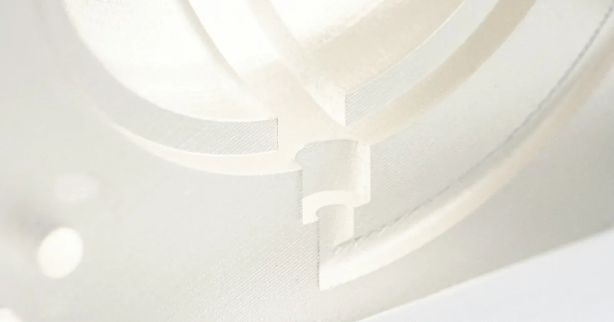 White 3D printed functional part with internal curved channels – illustrative engineering prototype